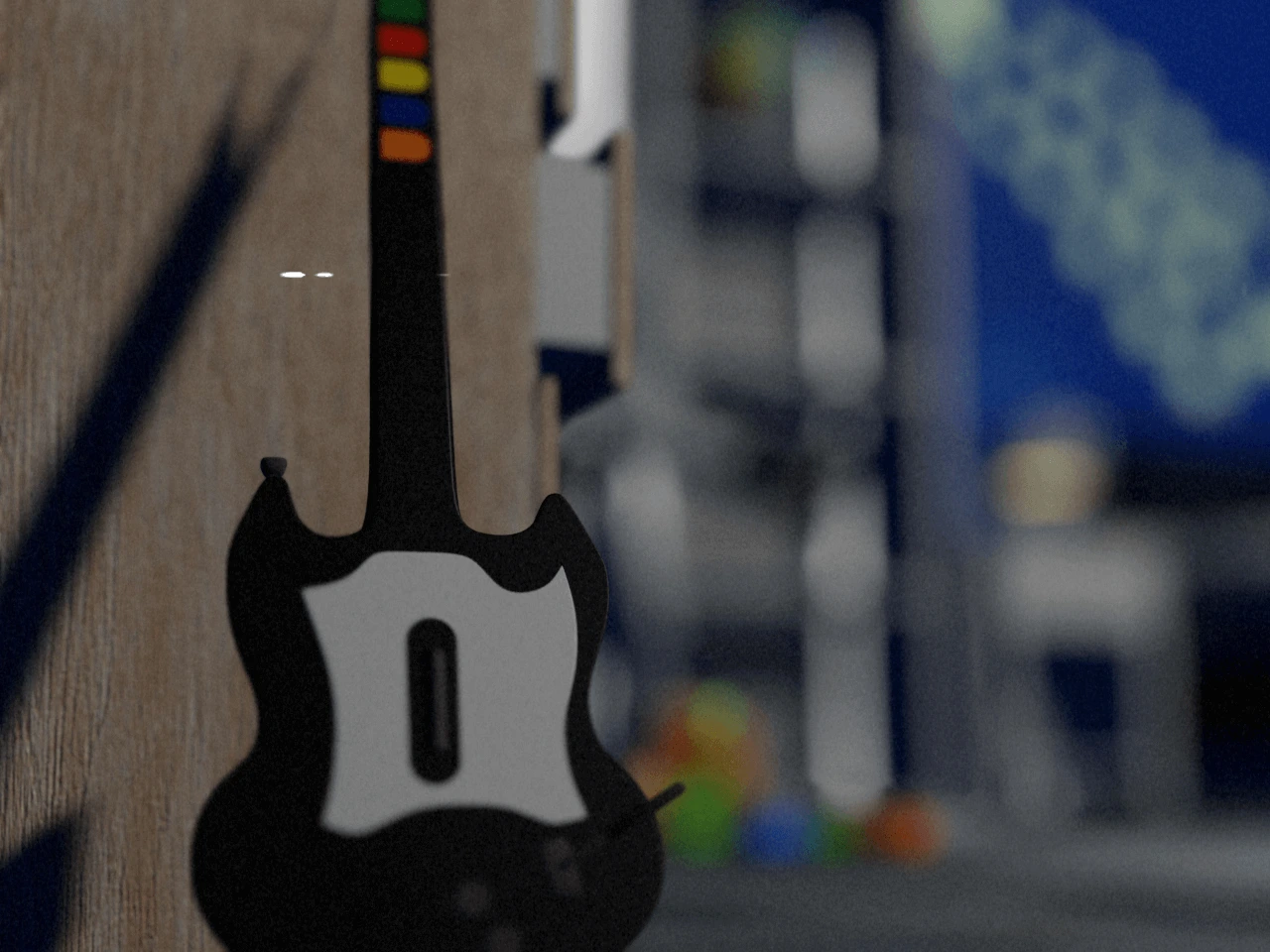an old guitar hero controller resting against a dresser
